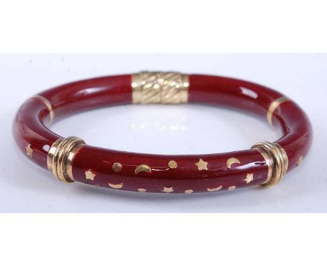 A yellow metal oval hinged hollow bangle, having red enamel inlay and star and crescent moon detail, bangle width 9.1mm, inne