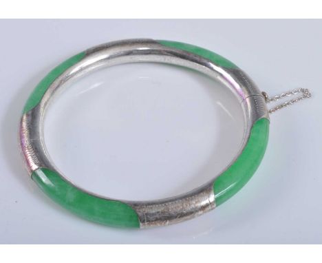 A late 20th century white metal and nephrite hinged bangle, the white metal stamped 925 and with engraved decoration, with sa