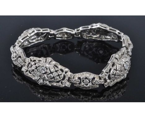 A white metal Art Deco style lozenge panel bracelet, comprising four larger links, each with a round white sapphire alternati