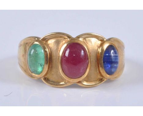 A continental 18ct gold dress ring, arranged as three cabochon coloured stones in red, blue and green, stamped 18k and 750, 3