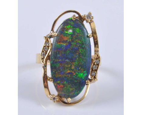 A yellow metal treated opal and diamond dress ring, the opal measuring approx 22 x 11.1 x 3.7mm, weight estimated as 4.69 car