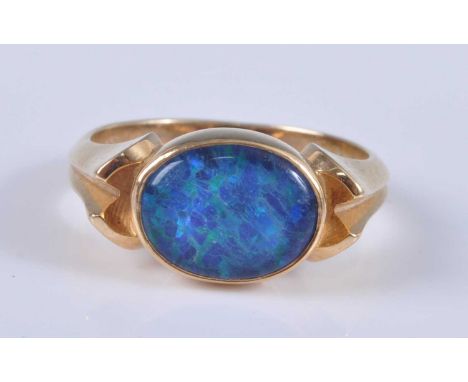 A yellow metal opal doublet set dress ring, the cabochon opal measuring approx 10 x 8mm, set to bifurcated shoulders, stamped