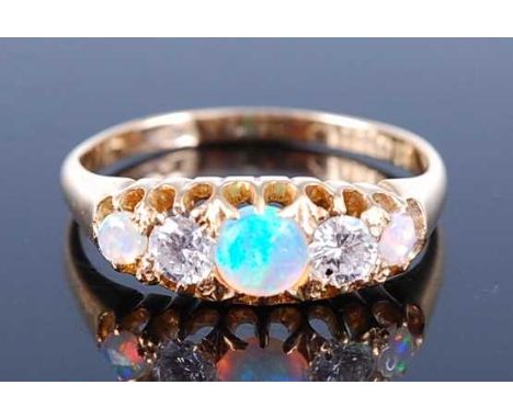 An 18ct yellow gold, opal and diamond half hoop eternity ring, featuring three graduated round opal cabochons and two modern 