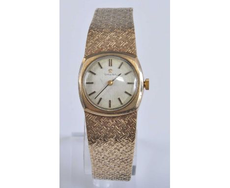 A lady's vintage Omega 9ct gold cased bracelet watch, having a signed champagne dial with baton markers, manual wind movement