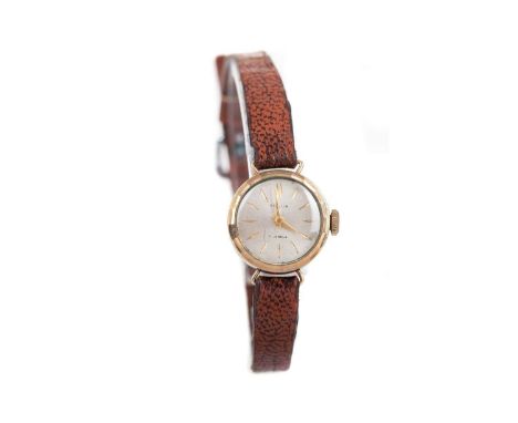 LADY'S VOLGA NINE CARAT GOLD MANUAL WIND WRIST WATCH,the round silvered dial with etched hour markers, 16mm case, on a brown 