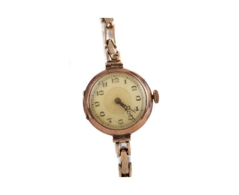LADY'S NINE CARAT GOLD MANUAL WIND WRIST WATCH,the round cream dial with Arabic hour markers, outer railroad seconds track in