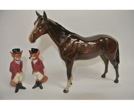 A Beswick model of a standing brown horse together with two Royal Doulton figures of standing foxes in hunting costume, numbe