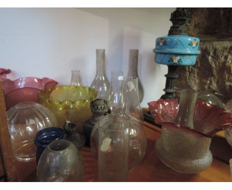 A collection of oil lamp and gass shades to include a frosted cranberry glass example with flared rim and etched foliate deco