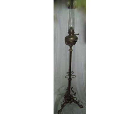 An Art Nouveau brass telescopic lamp standard with tripod base, with scrolled detail