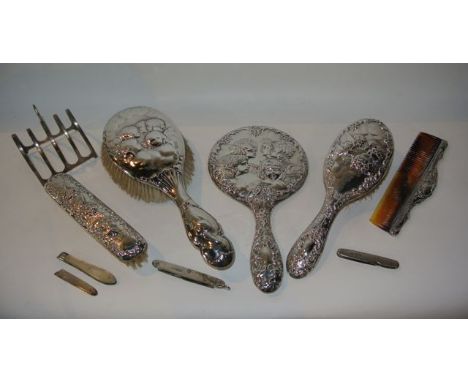 A silver dressing set, Birmingham, 1961, comprising: a hand mirror, a hair brush and a clothes brush, each with cherub decora