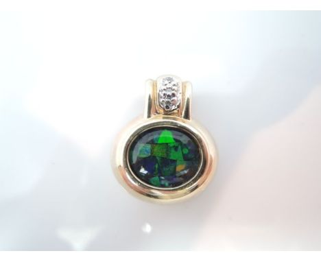 An imitation opal and diamond pendant, centred with an oval imitation black opal matrix, highlighted above with three brillia