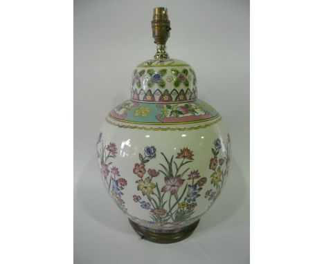 A lamp base in the form of a large ginger jar and cover with polychrome painted floral decoration on a white ground in the or