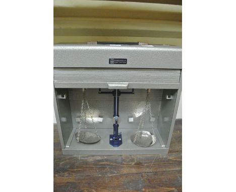 A cased travelling set of balance scales to a capacity of 200 g, number 1671, County of Avon in metalic case with tambour fro