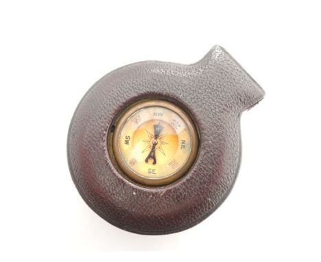 A pocket barometer and compass, with silvered dial, contained in a leather travelling case with window to view compass