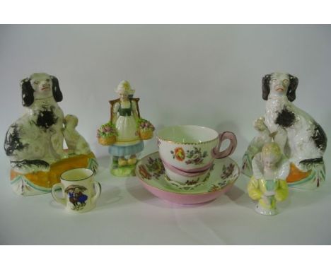 A pair of 19th century Staffordshire figures of black and white seated spaniels accompanied by their pups and raised on oval 