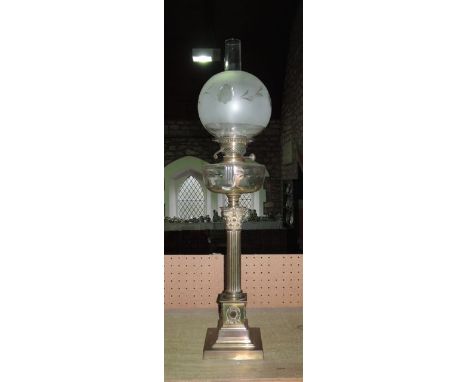 A brass Corinthian column oil lamp raised on a square cut base with cut glass reservoir