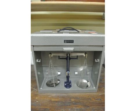 A cased travelling set of balance scales to a capacity of 200 g, number 1673, County of Avon in metalic case with tambour fro