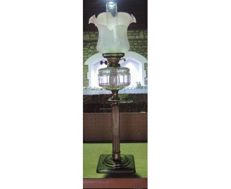 A Victorian brass oil lamp with reeded column, clear glass reservoir and platform base