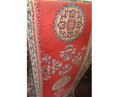 A Persian style runner with multi-medallion centre upon a mid red field within geometric borders, 280 x 70 cm