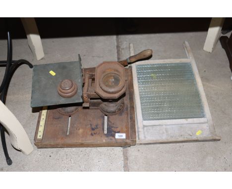 A vintage guillotine; a set of cast iron scales and weights; and a wash board 