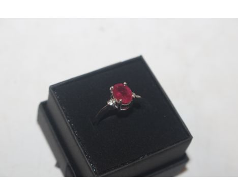 An 18ct white gold ring set with ruby coloured stone and diamond set shoulders, ring size N, approx. 3.2gms total weight