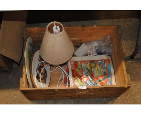 A vintage wooden crate and contents of a table lamp, playing cards, comic book etc.