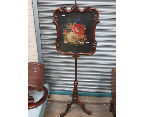 Victorian era firescreen in mahogany. Adjustable height screen has needlepoint Rose decoration behind a glass cover. Total he