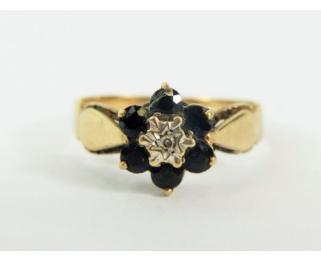 9ct Yellow Gold ring set with a small Central Diamond and surrounded by  six small Sapphires. .. Finger size  'R'     3.0g