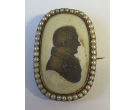 John Field, A Georgian portrait silhouette, of a man, signed, in a yellow metal brooch mount set with a frame of pearls, the 