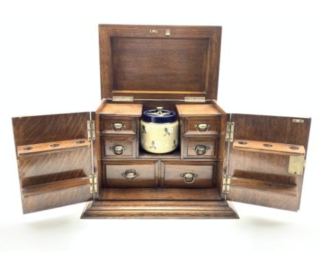 Edwardian oak smokers cabinet enclosed by panelled doors and with hinged lid, fitted interior with small drawers, pipe racks 