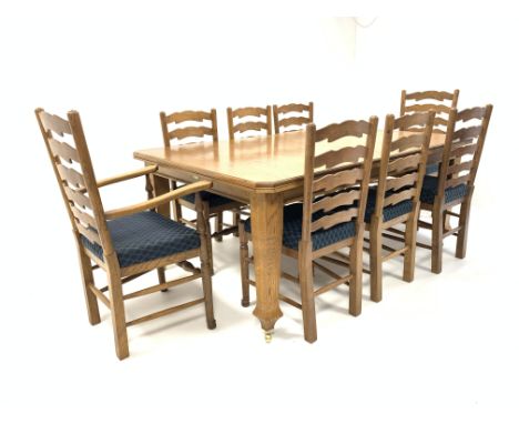 Solid oak telescopic dining table, the top with canted corners, raised on square supports and brass castors, with leaf,  (122