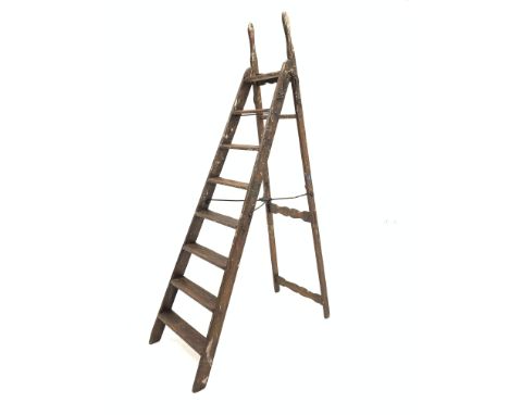 Late 19th/early 20th century stained pine simplex step ladder, the 'A' frame with seven rungs, secured by self acting stop, c