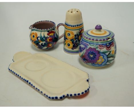 A Poole Pottery dish; together with a preserve pot and cover; cream jug; and a sugar caster (4)