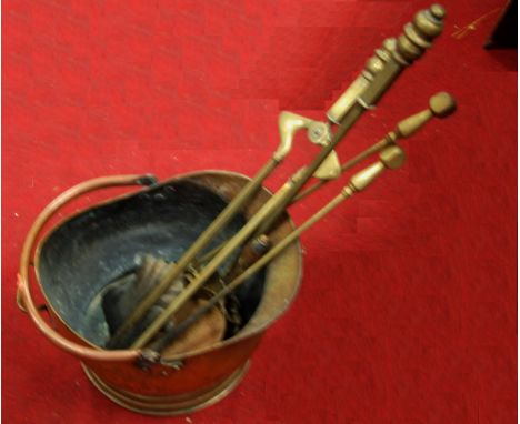 An early 20th century brass helmet shaped coal scuttle; together with various turned brass fire tools; and a Victorian painte