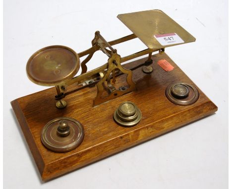 A set of brass post office scales and weights on oak plinth base