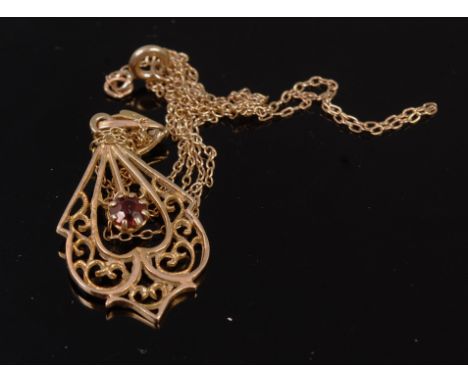 A modern 9ct gold garnet set openwork pendant on finelink neck chain, gross weight 3g