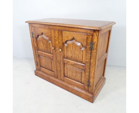 A reproduction oak two-door cabinet, with fielded panels and  shelf fitted interior. 92x77x41cm. 