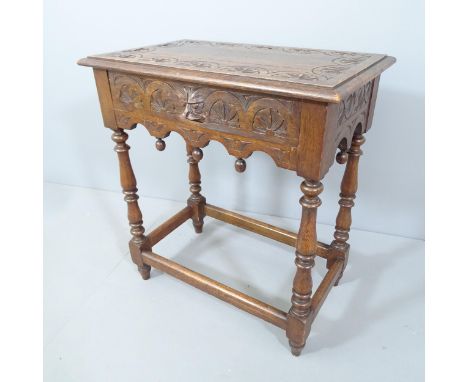 An antique carved oak side table, on turned legs with all around stretcher and carved green man decoration. 66x72x40cm. 