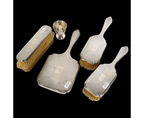 A George V engine turned silver-backed dressing table brush and mirror set (6), and a silver egg cup 