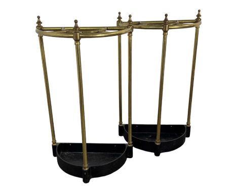 PAIR OF BRASS DEMI-LUNE STICK STANDS, EARLY TO MID-20TH CENTURY each with three cylindrical supports, over cast iron base64cm