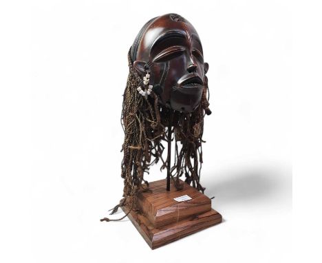 TWO AFRICAN CHOKWE MASKS, LATE 19TH CENTURY  each mounted on a stand with carved detail largest 60cm high overall 