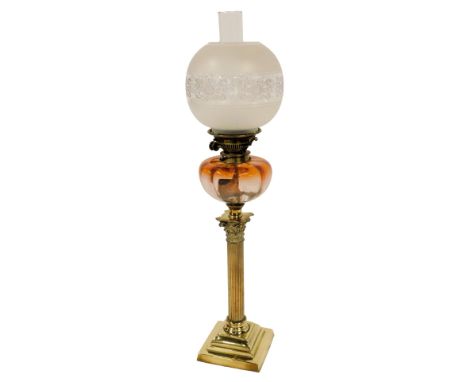A Victorian oil lamp, with globular etched and clear glass shade, chimney, with a graduated amber glass central reservoir, on
