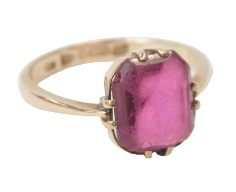 A 9ct rose gold and ruby coloured stone ring, claw set, size K, 2.3g. 