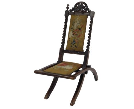 A Victorian mahogany folding chair, with pierced scroll and shell carved back, with barley twist supports, a floral tapestry 