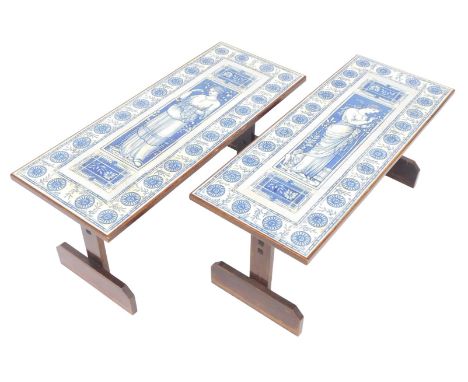 A pair of 20thC tile top and oak coffee tables, decorated with female figure within a floral border, on shaped end supports u