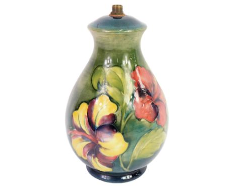 A Moorcroft pottery lamp base decorated in the Hibiscus pattern, graduated green ground, paper label, 22cm high. 