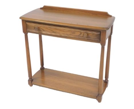 An Ercol elm side table, with raised back and a frieze drawer, on turned legs with under tier, 74cm high, 78cm wide, 30cm dee