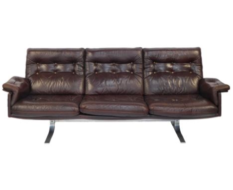 A late 20thC century brown leather three seater sofa, with button seat, back and arms, on out swept metal legs, possibly Scan
