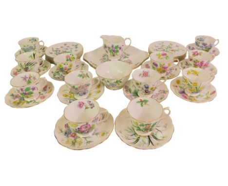A Royal Albert porcelain Flower of the Month series tea service, comprising a pair of bread plates, cream jug and sugar bowl,