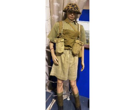A near complete British WWII period tropical uniform and pack, with webbing and Brodie helmet, most components dated 1940-194